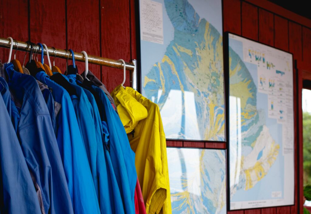 three world map photograph beside some rain coats