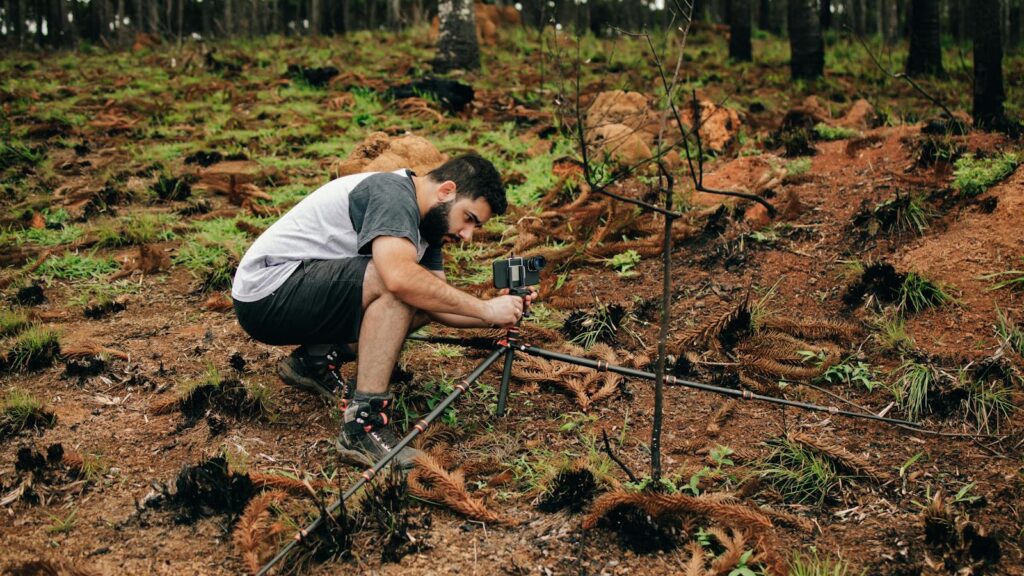 A man setting up equipment in a forest for environmental research.
