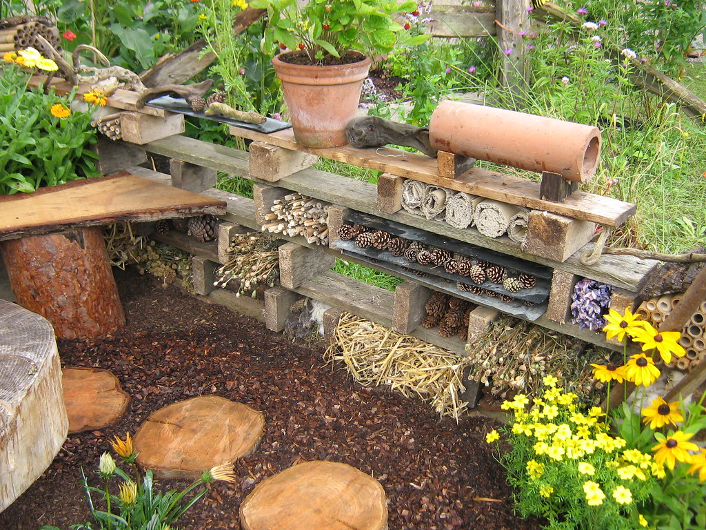 Insect hotel placed among lush vegetation.