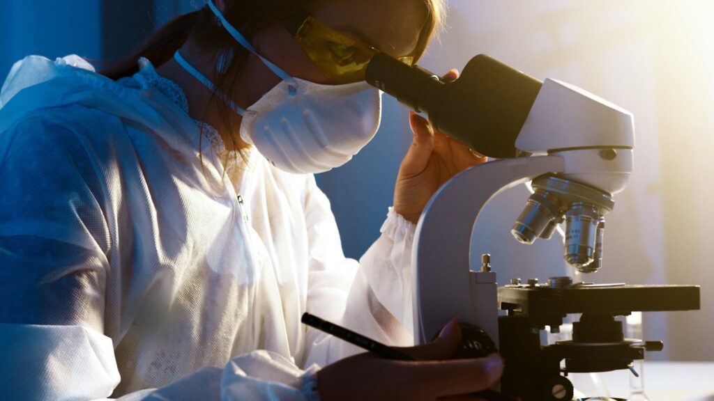 Scientist examining specimen through a microscope.