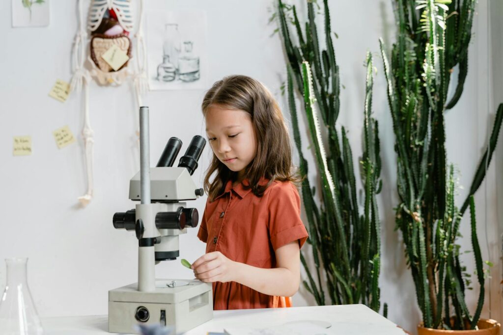 A little girl using microscope for a scientific research.