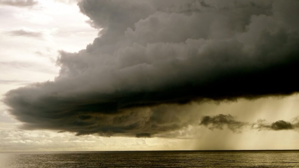 A gray nimbus clouds above body of water
