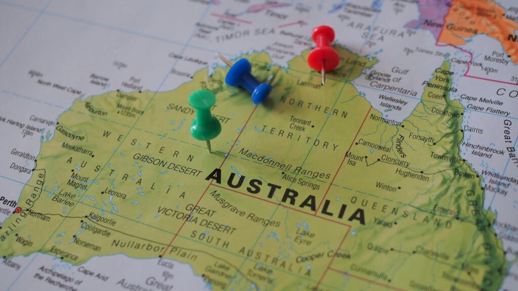 Close-up of a map of Australia featuring colorful pushpins marking locations.