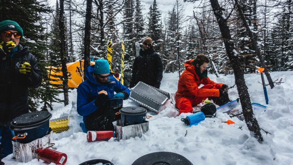 people sitting on snow covered ground during daytime