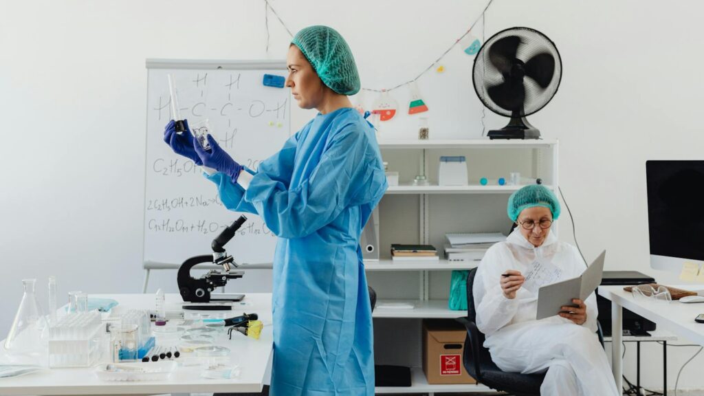 Researchers work in a laboratory analyzing samples, featuring vials and scientific equipment.