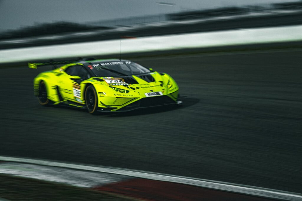 A yellow sports car driving on a race track