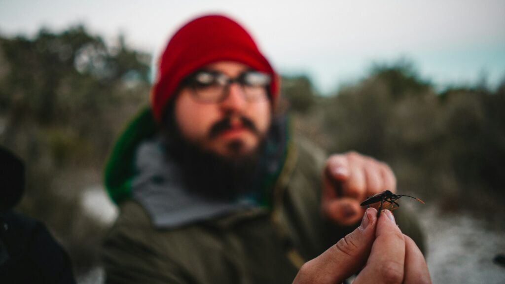 a man holding a small insect in his hand