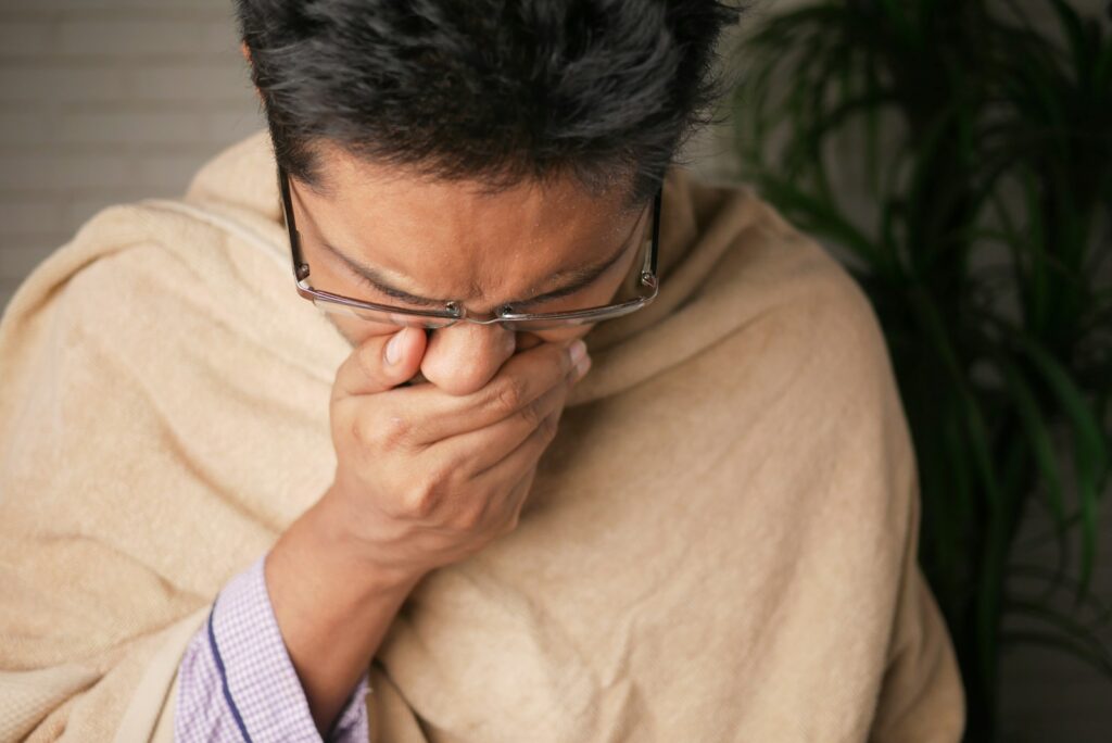 Man in brown sweater wearing black-framed eyeglasses