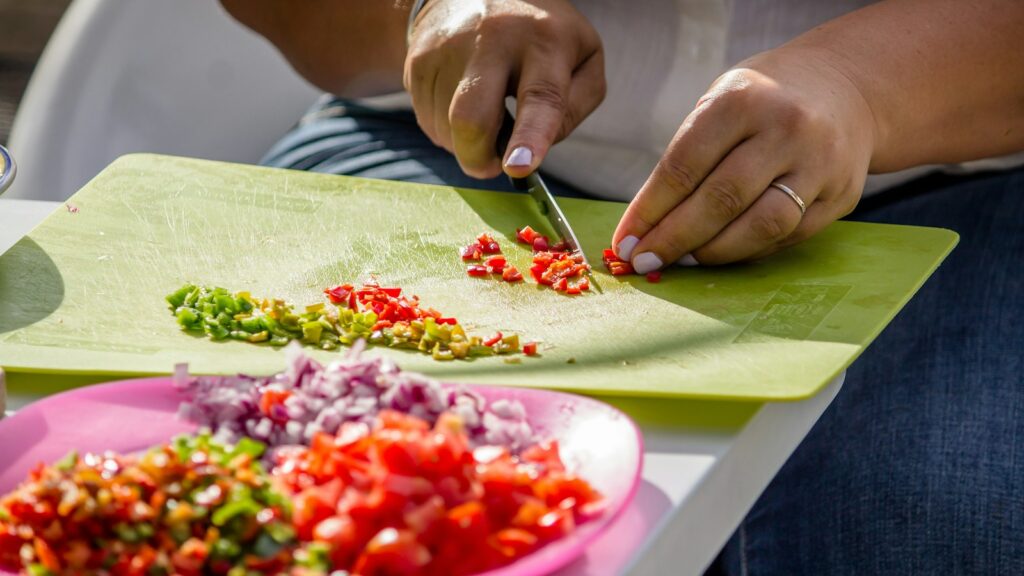 person slicing species on green chopping board
