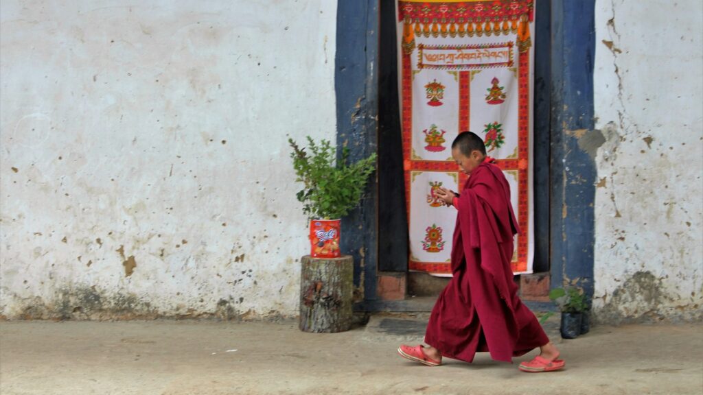 A woman in a red robe walking past a doorway