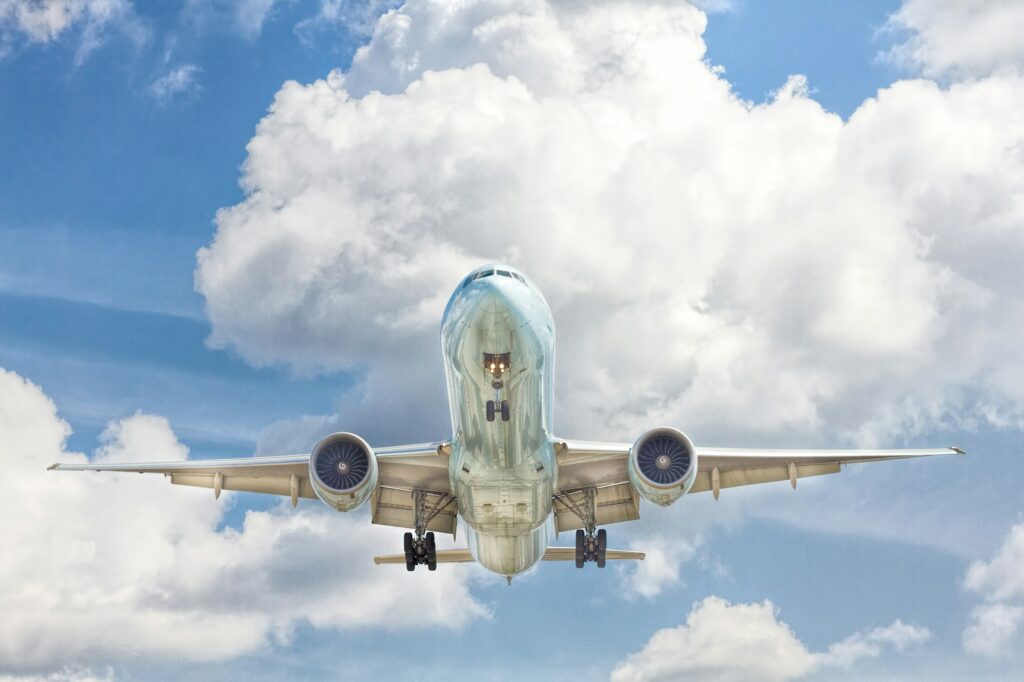 Gray and white airplane on flight near clear blue sky