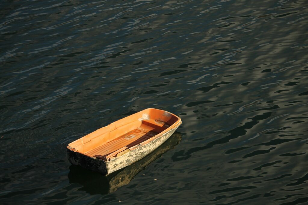 A small boat floating on top of a body of water